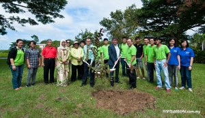 (L-R) Nicholas Leong, Prof Ian Kerr and Nicholas Ching planting guava tree while CEC members and exhibition participants look on.